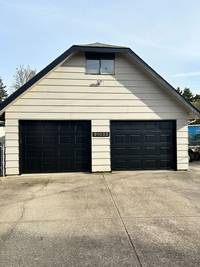 The deep black garage doors create a striking contrast, adding a touch of modernity and timeless style.