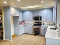 The cabinets were transformed with a soft blue gray tone, giving the kitchen a fresh, modern, and airy vibe.