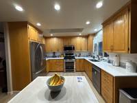 The kitchen cabinets had a classic wood finish that added warmth but made the space feel darker and more traditional.