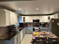 Detail view of freshly painted white upper cabinets enhancing light and creating a crisp, modern kitchen interior.