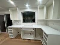 Freshly painted built-in cabinets with a clean white finish, creating a bright and modern workspace.