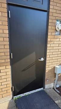 Freshly painted exterior door with a smooth black finish that gives it a clean and updated look.