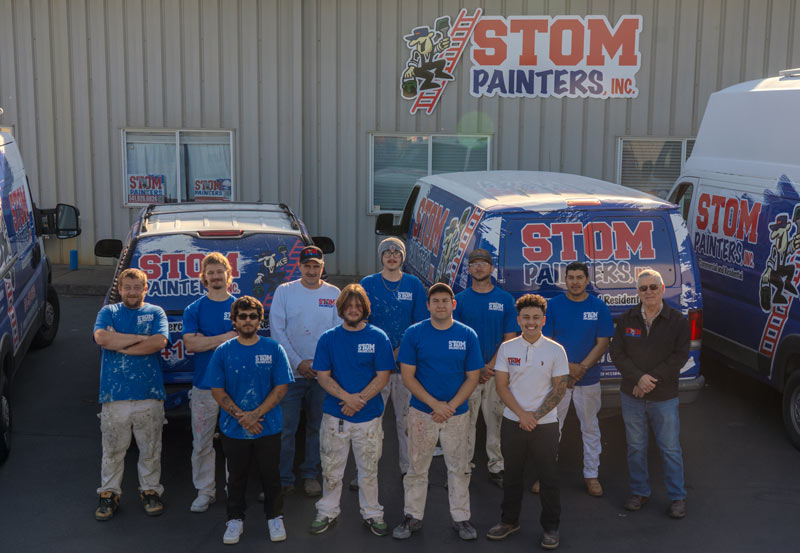 Stom Painters crew in front of their fleet of vehicles and office.